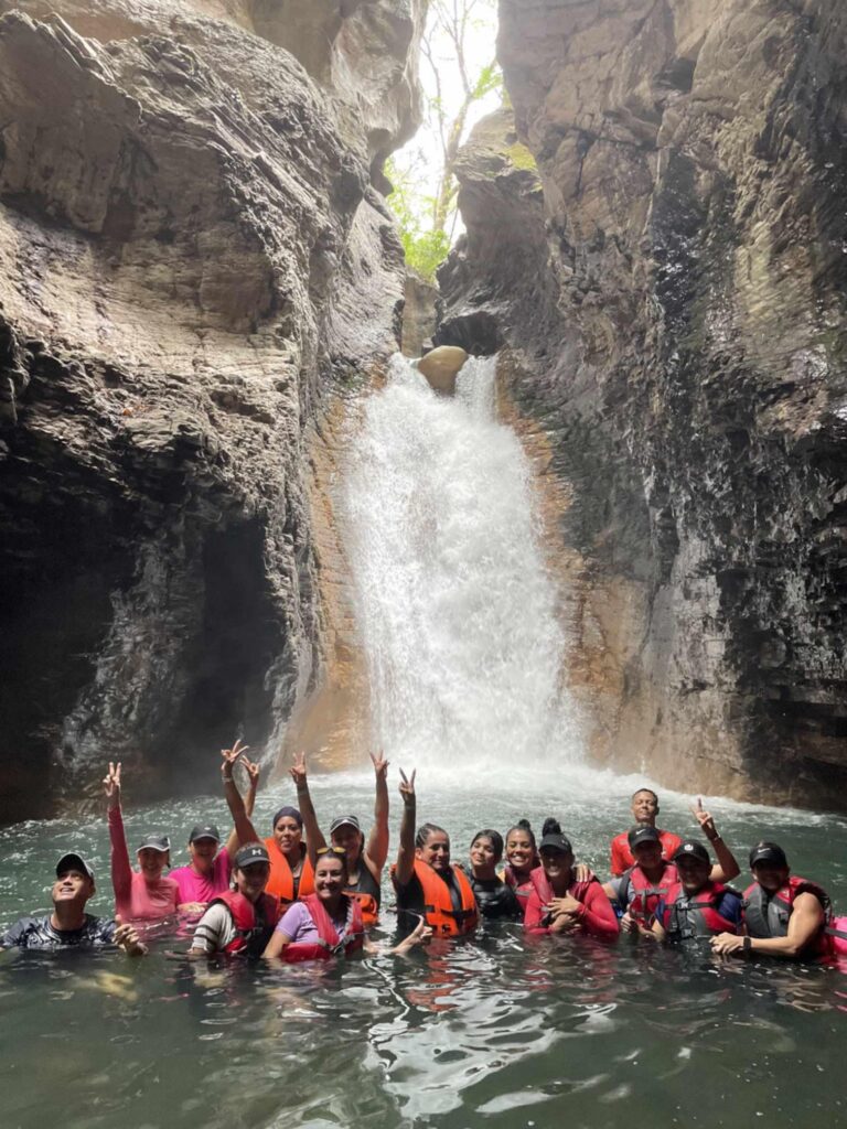 Big Group Under Waterfall Group enjoying La Leona Waterfall Brasilito Tours