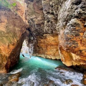 Crystal blue waters leading into a cave you can swim through